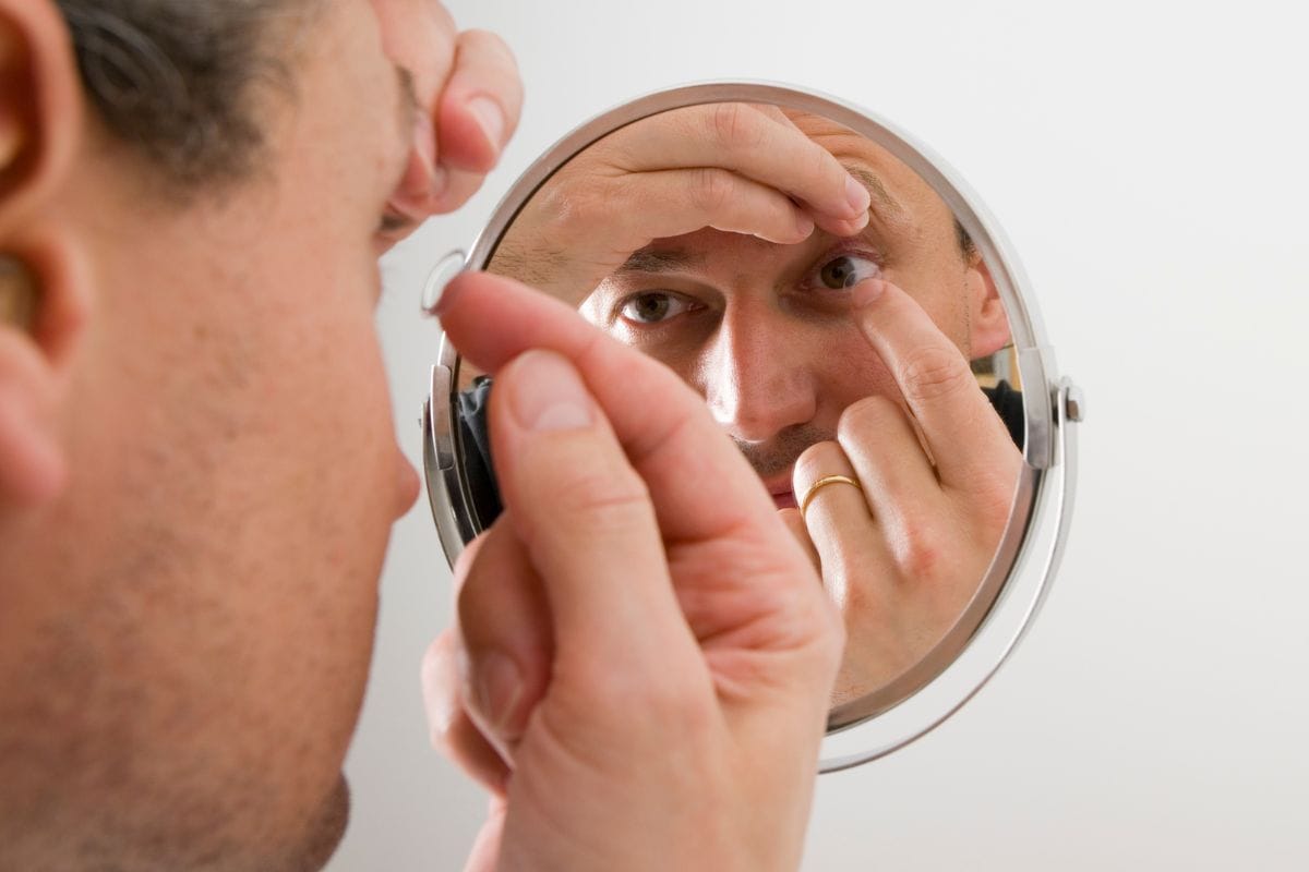 man-inserting-a-contact-lens-in-his-eye