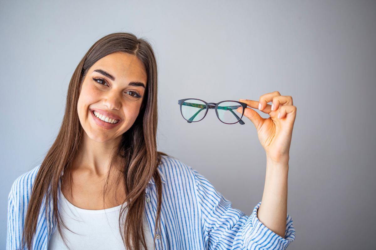 woman-smiling-holding-eyeglasses