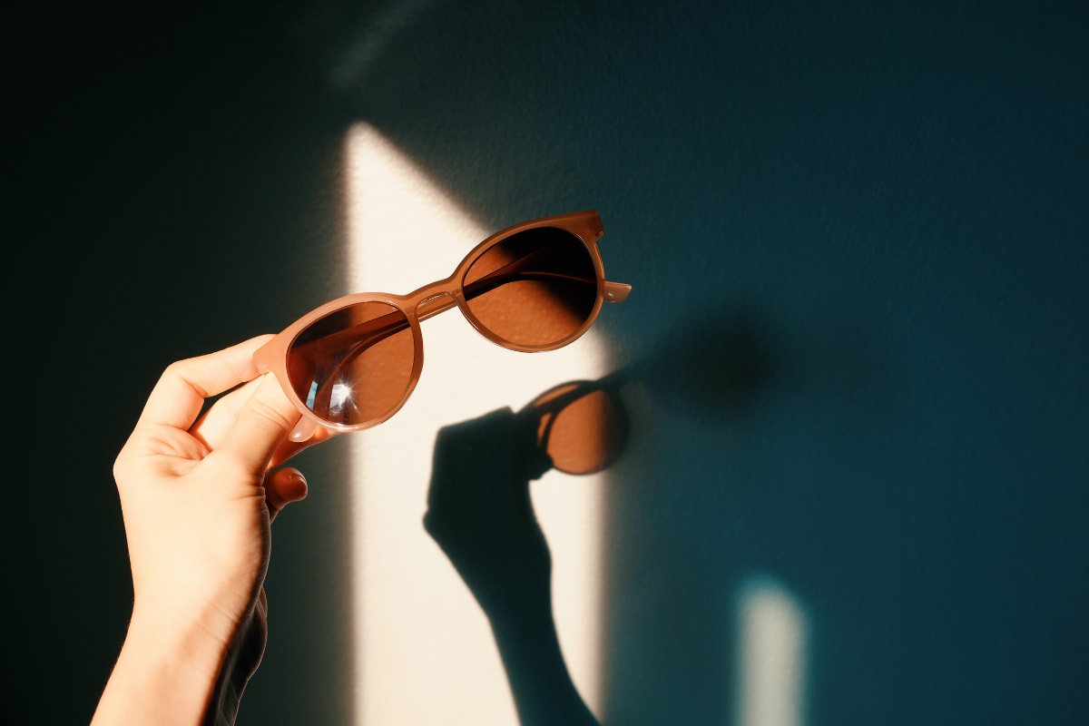 person-holding-sunglasses