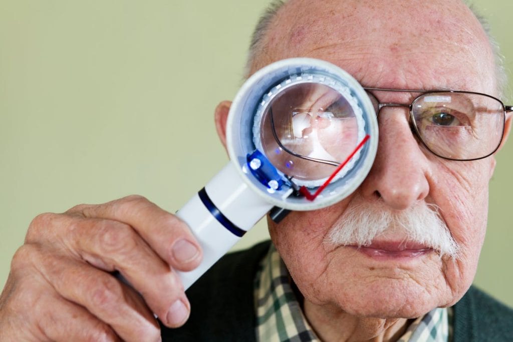 senior-man-holding-an-illuminated-magnifying-glass