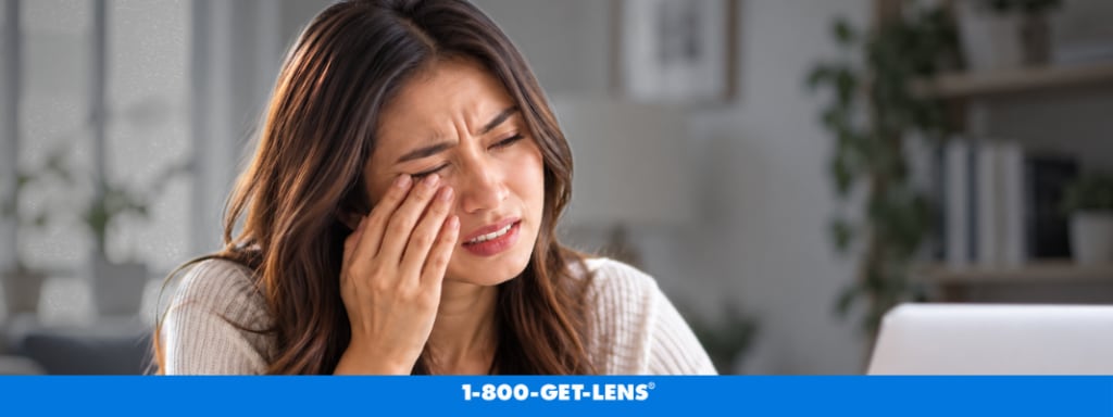 Woman gently touching her lower eyelid while experiencing eye twitching